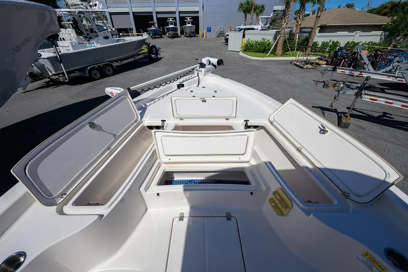 Slide: The Image of 2021 Blue Wave 2600 PureBay boat with open storage compartments in a marina setting. - 17