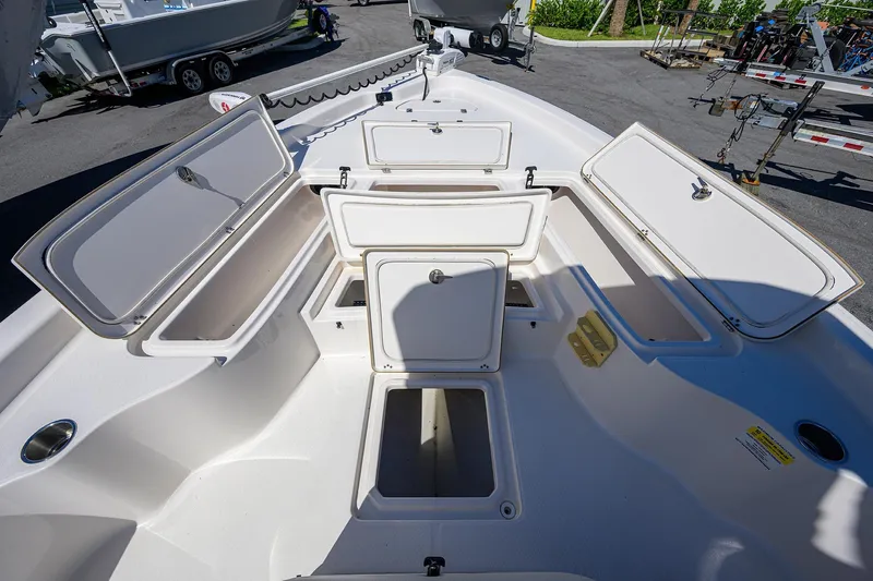 Slide: The Image of 2021 Blue Wave 2600 PureBay boat with open storage compartments on deck. - 20