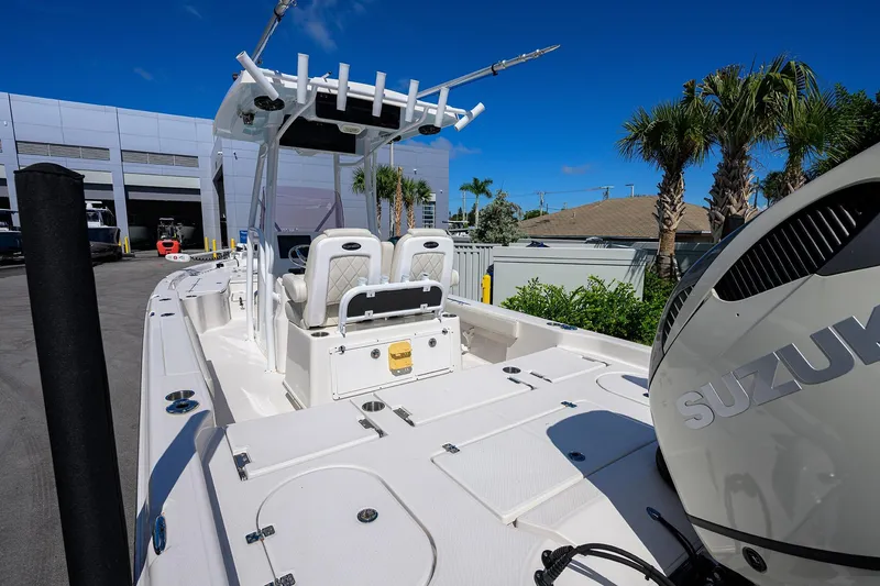 Slide: The Image of 2021 Blue Wave 2600 PureBay boat with Suzuki engine, docked near palm trees. - 22