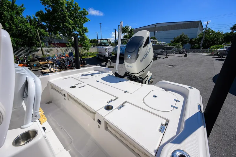 Slide: The Image of 2021 Blue Wave 2600 PureBay boat with Suzuki engine, parked outdoors under clear blue sky. - 24