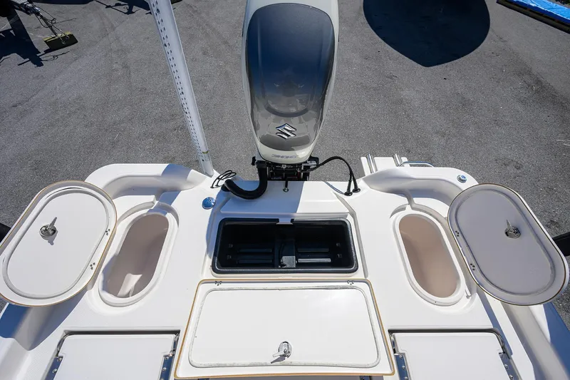 Slide: The Image of 2021 Blue Wave 2600 PureBay boat deck with Suzuki outboard motor and storage compartments. - 27