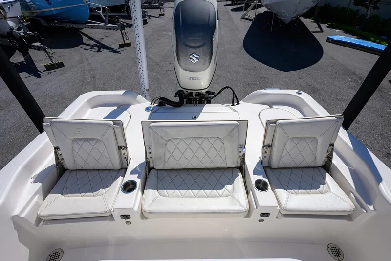 Slide: The Image of 2021 Blue Wave 2600 PureBay boat with three white cushioned seats and Suzuki engine. - 30
