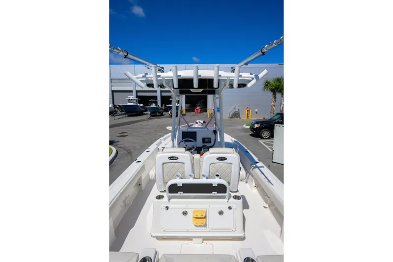 Slide: The Image of 2021 Blue Wave 2600 PureBay boat interior with seating and console, parked outdoors. - 33