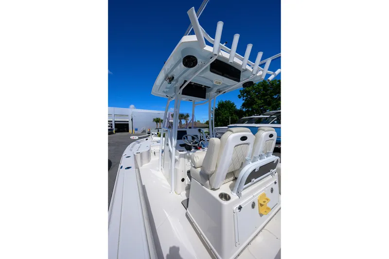 Slide: The Image of 2021 Blue Wave 2600 PureBay boat interior with seating and console, under clear blue sky. - 41