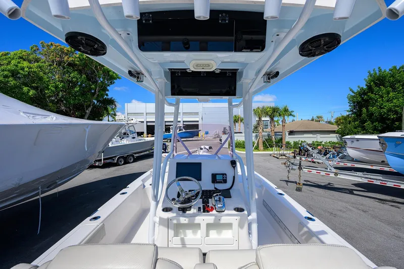 Slide: The Image of 2021 Blue Wave 2600 PureBay boat interior with steering console, parked outdoors. - 44