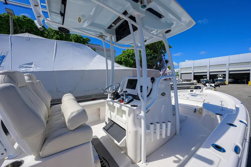 Slide: The Image of 2021 Blue Wave 2600 PureBay boat interior with helm and seating, under clear blue sky. - 47