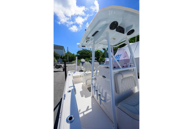 Slide: The Image of 2021 Blue Wave 2600 PureBay boat interior with seating and T-top under blue sky. - 49