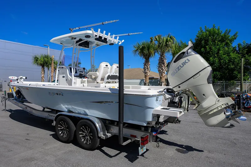 Slide: The Image of 2021 Blue Wave 2600 PureBay boat with Suzuki engine on trailer, parked outdoors. - 6