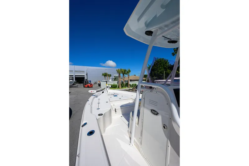 Slide: The Image of 2021 Blue Wave 2600 PureBay boat, white exterior, parked outdoors under clear blue sky. - 9