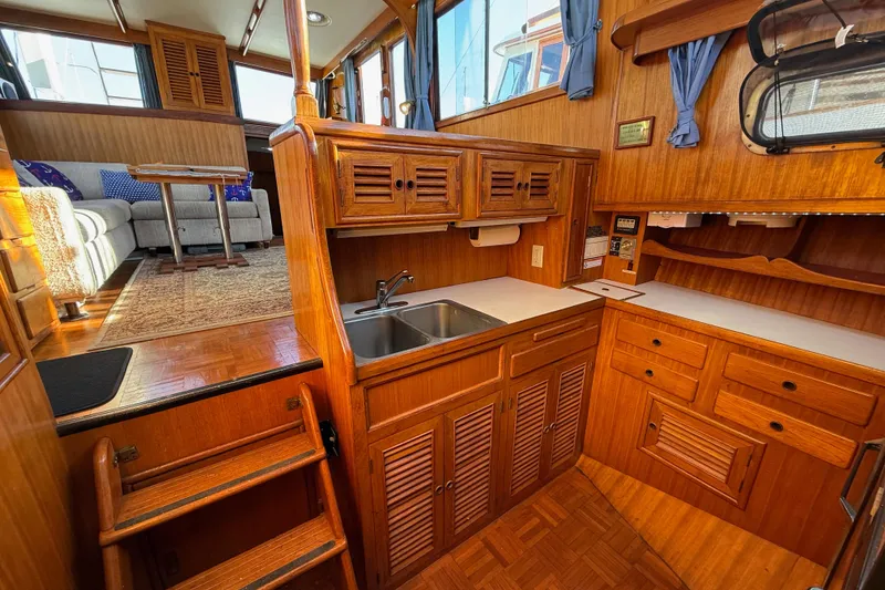 Slide: The Image of 1983 CHB 41 Classic Trawler interior with wooden cabinetry and cozy seating area. - 11