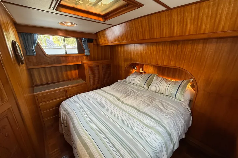 Slide: The Image of Cozy bedroom in 1983 CHB 41 Classic Trawler with wood paneling and striped bedding. - 17