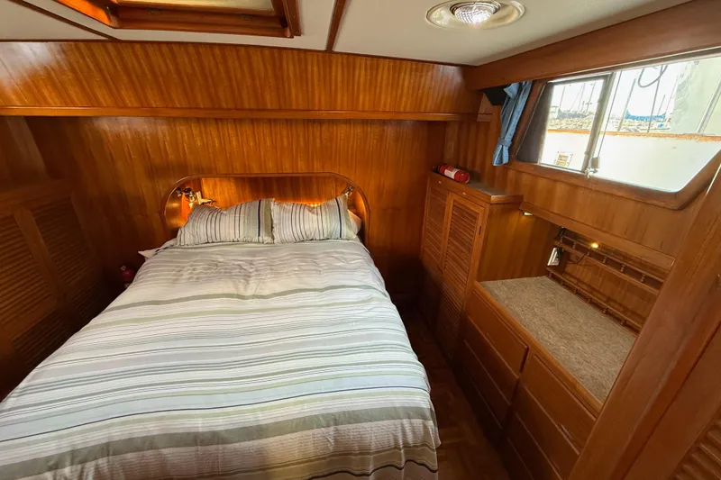 Slide: The Image of Cozy bedroom in 1983 CHB 41 Classic Trawler with wood paneling and striped bedding. - 18