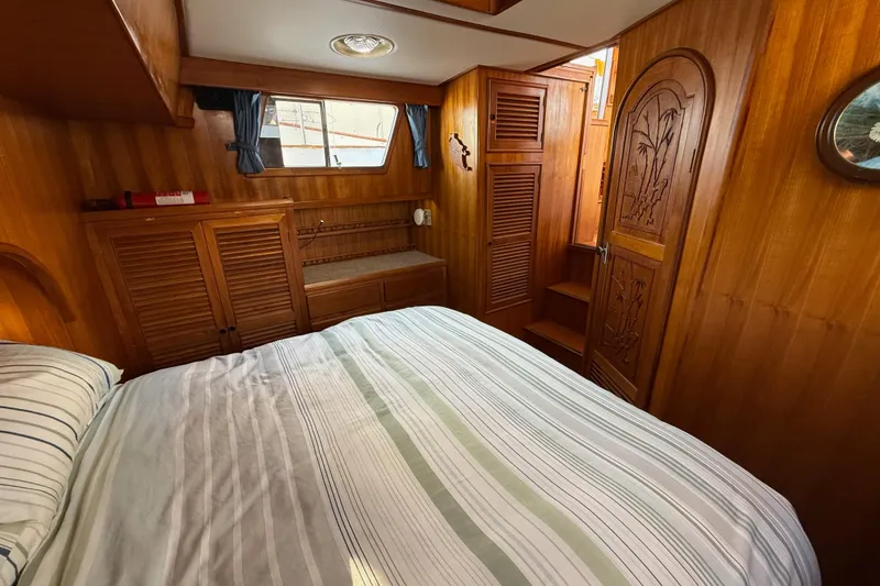Slide: The Image of Cozy cabin interior of 1983 CHB 41 Classic Trawler with wood paneling and striped bedding. - 19