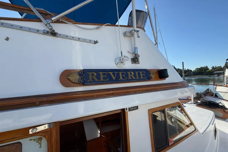 Slide: The Image of 1983 CHB 41 Classic Trawler "Reverie" docked, showcasing elegant woodwork and nautical design. - 23