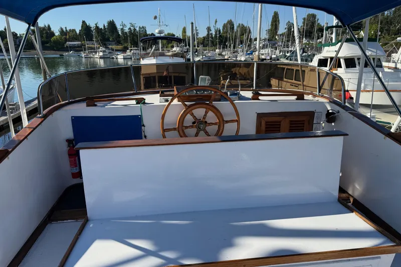 Slide: The Image of 1983 CHB 41 Classic Trawler at marina, featuring wooden helm and spacious deck. - 24