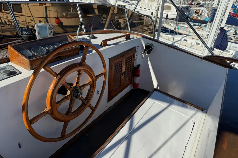 Slide: The Image of 1983 CHB 41 Classic Trawler helm with wooden wheel and navigation instruments. - 25