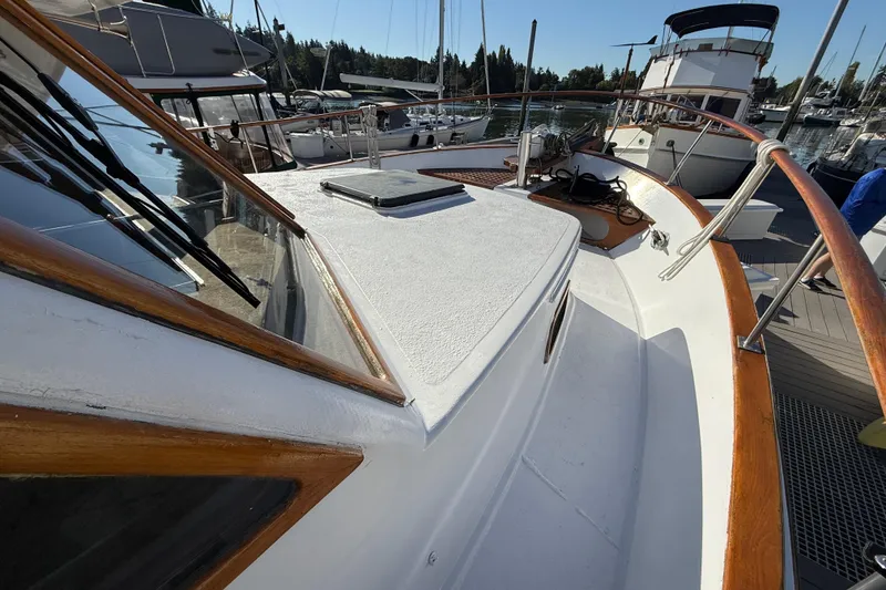 Slide: The Image of 1983 CHB 41 Classic Trawler docked, showcasing deck and wooden railings. - 27