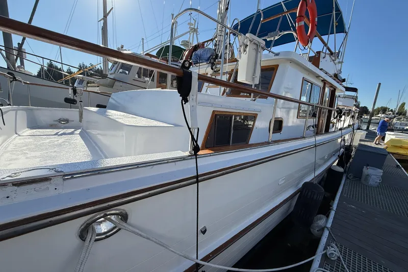 Slide: The Image of 1983 CHB 41 Classic Trawler docked at marina under clear blue sky. - 28