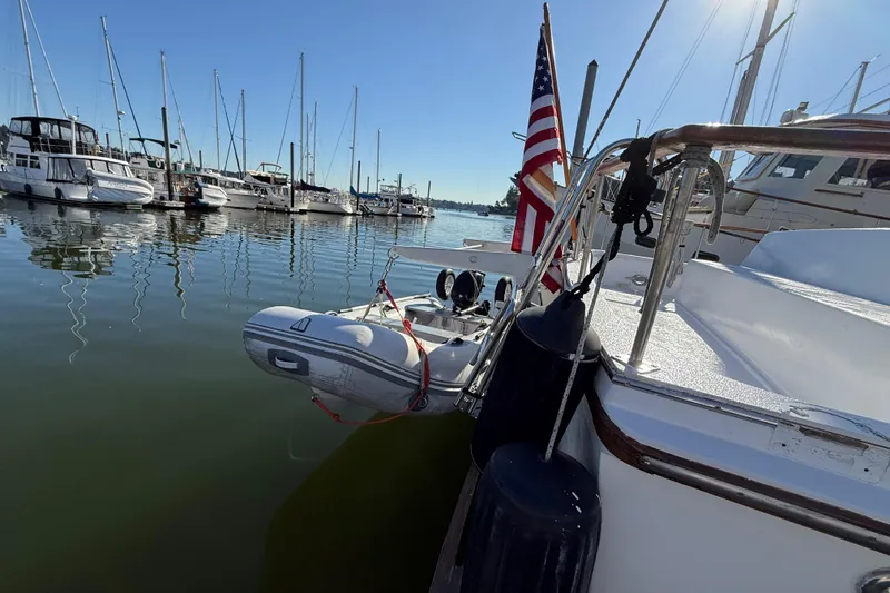 Slide: The Image of 1983 CHB 41 Classic Trawler docked with dinghy and American flag in marina. - 29