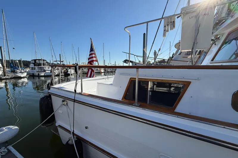 Slide: The Image of 1983 CHB 41 Classic Trawler docked at marina, American flag displayed, sunny day. - 30