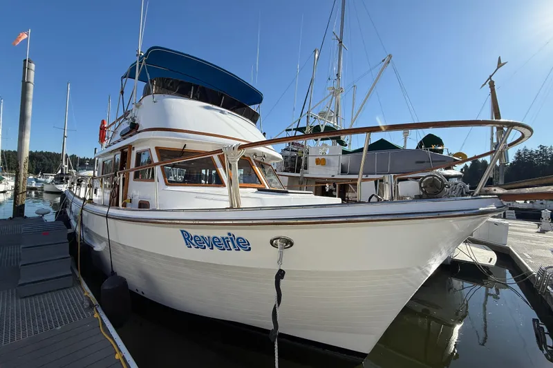 Slide: The Image of 1983 CHB 41 Classic Trawler "Reverie" docked at marina under clear blue sky. - 31
