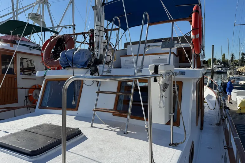 Slide: The Image of 1983 CHB 41 Classic Trawler docked, featuring upper deck and nautical equipment. - 36