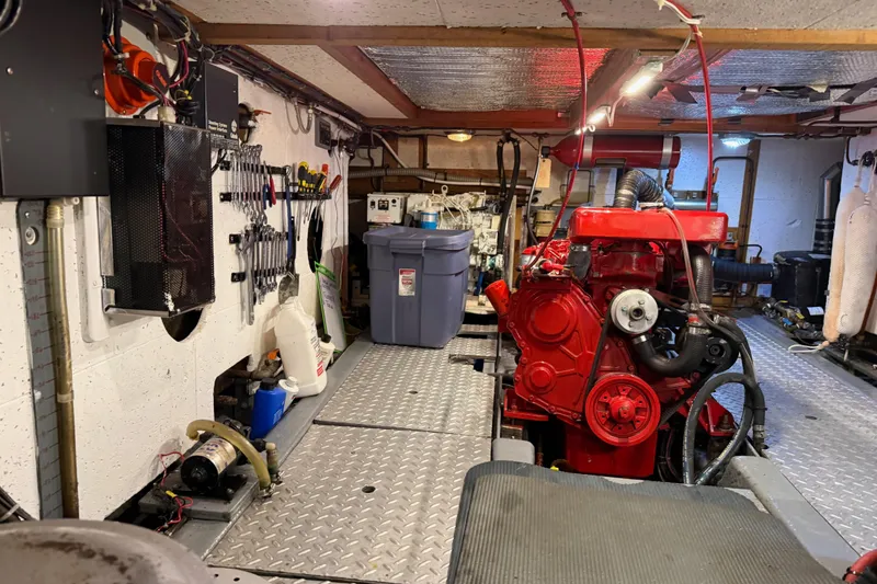 Slide: The Image of Engine room of 1983 CHB 41 Classic Trawler with red engine and organized tools. - 41