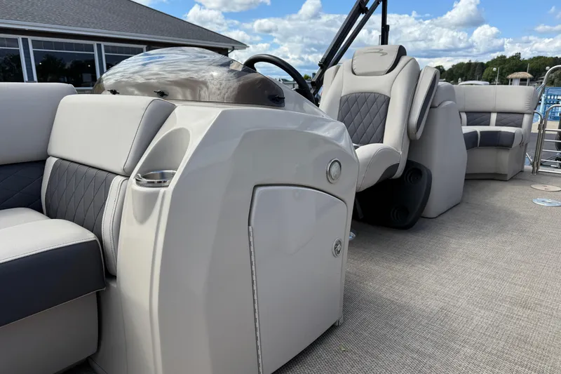 Slide: The Image of 2019 Bennington 22SX Premier boat interior with luxurious seating and helm, under a blue sky. - 11