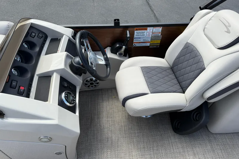 Slide: The Image of 2019 Bennington 22SX Premier boat interior with steering wheel and cushioned captain's chair. - 12