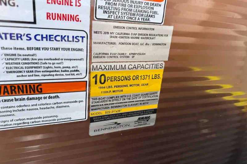 Slide: The Image of Warning and capacity labels on 2019 Bennington 22SX Premier boat, detailing safety and weight limits. - 14