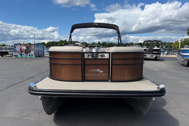 Slide: The Image of 2019 Bennington 22SX Premier pontoon boat on a sunny day, parked on a marina lot. - 2