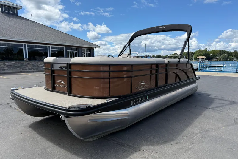 Slide: The Image of 2019 Bennington 22SX Premier pontoon boat parked near a waterfront building. - 3