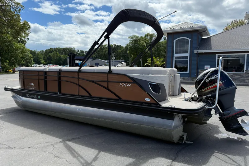 Slide: The Image of 2019 Bennington 22SX Premier pontoon boat with Yamaha engine, parked outdoors. - 5