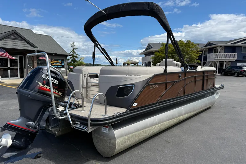 Slide: The Image of 2019 Bennington 22SX Premier pontoon boat with Yamaha motor, parked outdoors. - 7