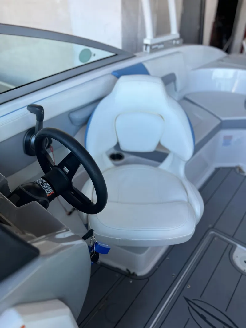 Slide: The Image of 2022 Chaparral 23 Surf boat interior with captain's chair and steering wheel. - 10