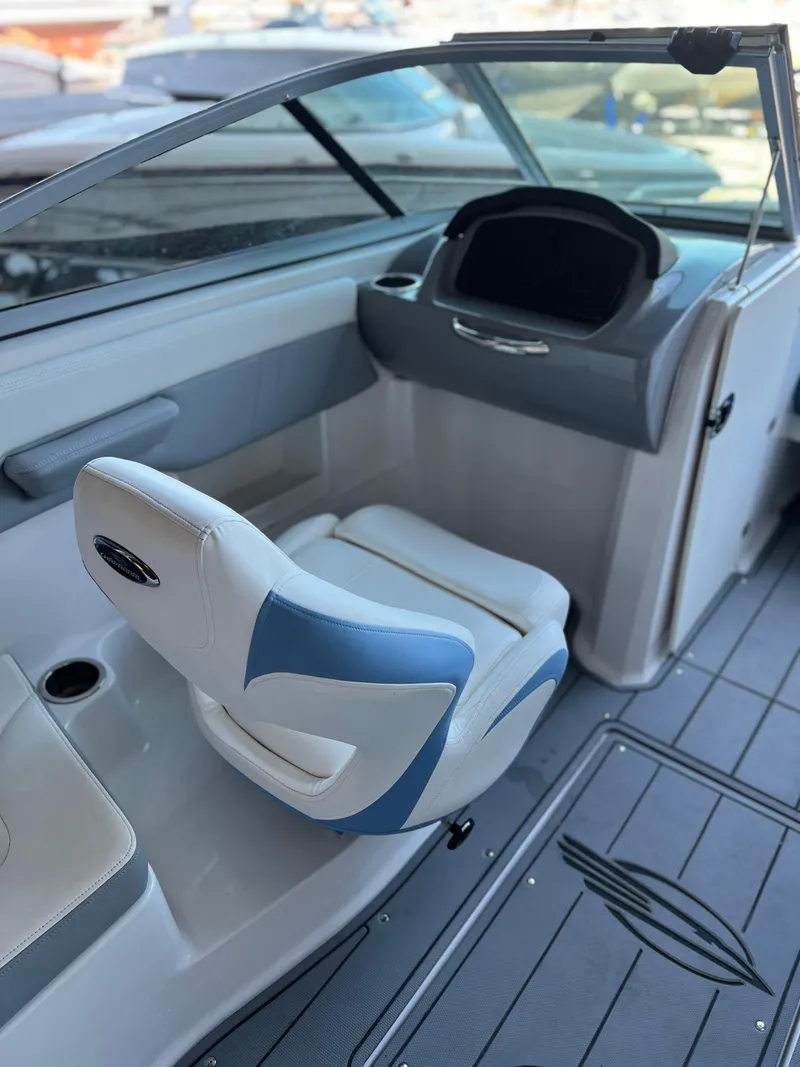 Slide: The Image of 2022 Chaparral 23 Surf boat interior with captain's chair and dashboard. - 11