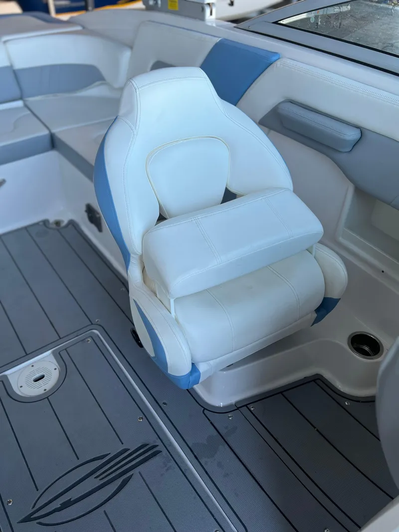 Slide: The Image of 2022 Chaparral 23 Surf boat interior with white and blue seating. - 12