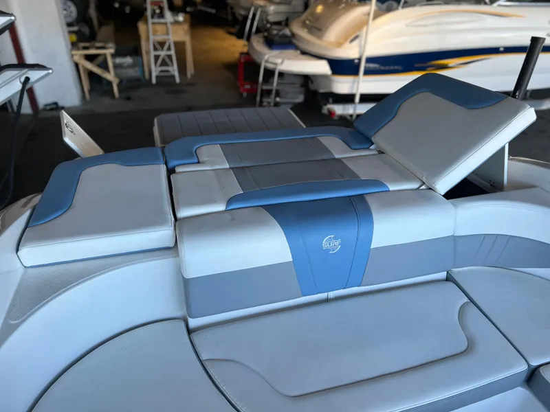 Slide: The Image of 2022 Chaparral 23 Surf boat interior with blue and gray seating. - 13