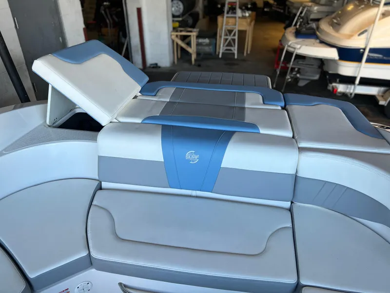 Slide: The Image of 2022 Chaparral 23 Surf boat interior with blue and white seating. - 14