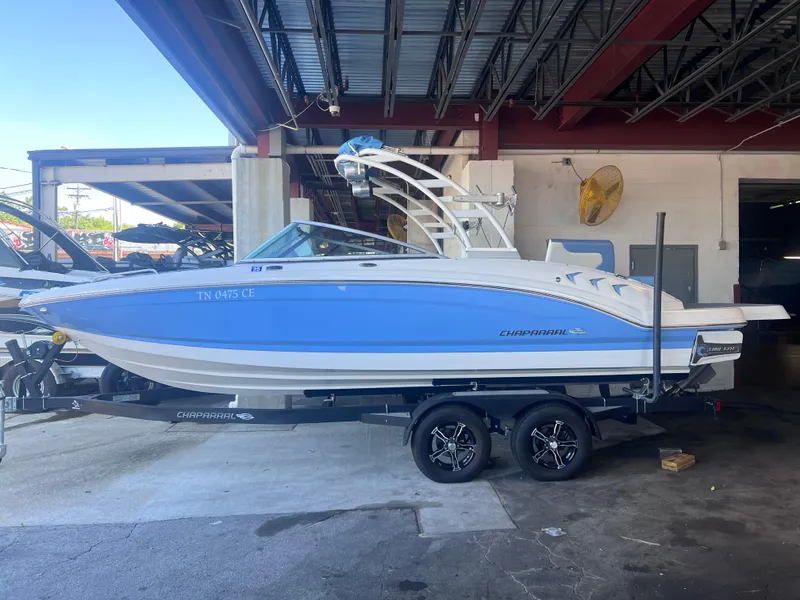 Slide: The Image of 2022 Chaparral 23 Surf boat on trailer in a covered storage area. - 2
