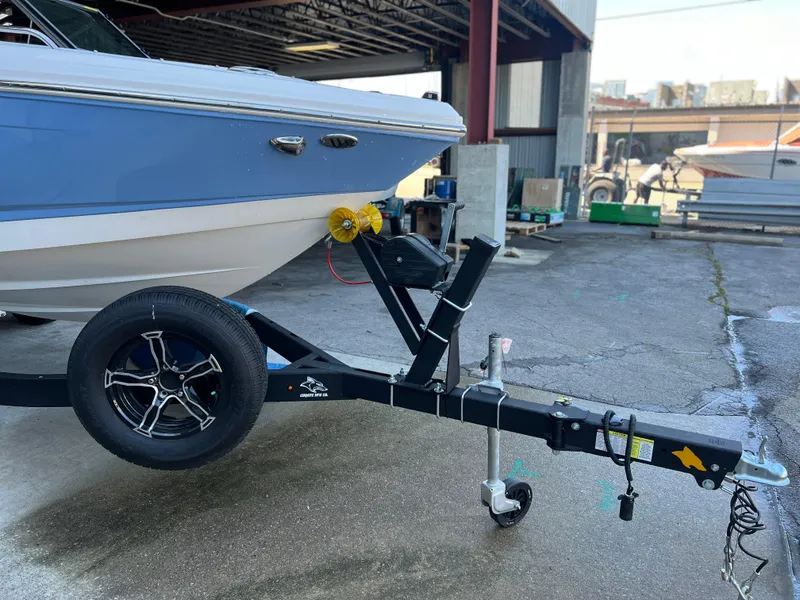 Slide: The Image of 2022 Chaparral 23 Surf boat on trailer in a marina. - 24