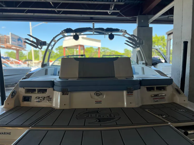 Slide: The Image of 2022 Chaparral 23 Surf boat, rear view, in a showroom setting. - 26