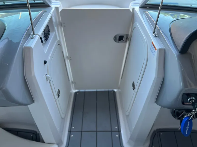 Slide: The Image of 2022 Chaparral 23 Surf boat interior with storage compartments and gray flooring. - 4