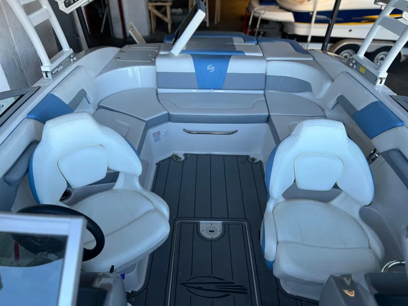 Slide: The Image of 2022 Chaparral 23 Surf boat interior with white and blue seating. - 8