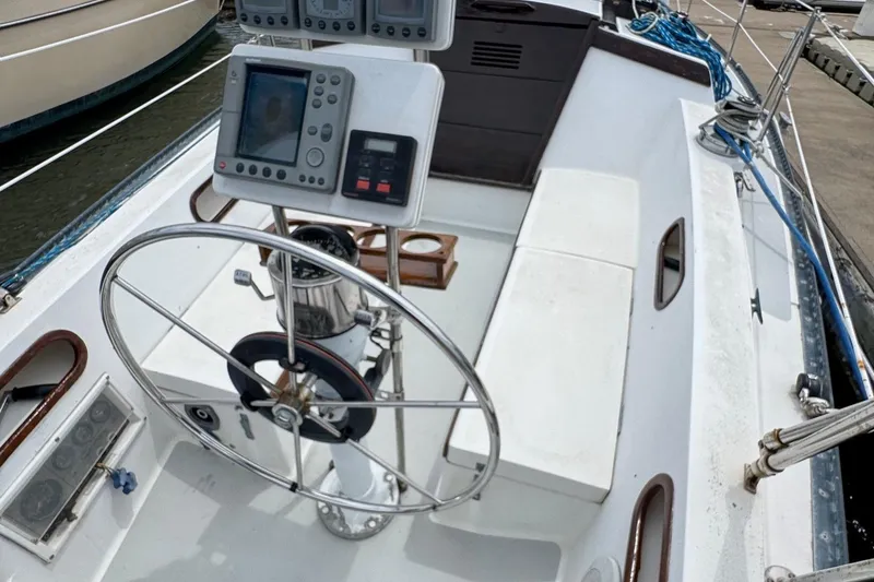 Slide: The Image of 1986 Catalina 38 sailboat cockpit with steering wheel and navigation instruments. - 11