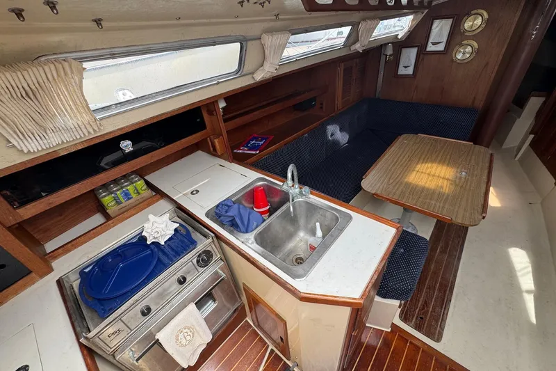 Slide: The Image of Interior of a 1986 Catalina 38 sailboat featuring a cozy kitchen and dining area. - 18