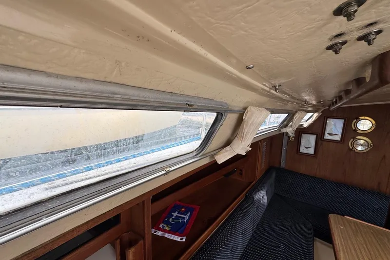 Slide: The Image of Interior of a 1986 Catalina 38 sailboat with windows, seating, and nautical decor. - 28