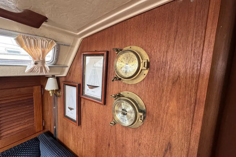 Slide: The Image of Interior of 1986 Catalina 38 sailboat with brass instruments and framed nautical art. - 29