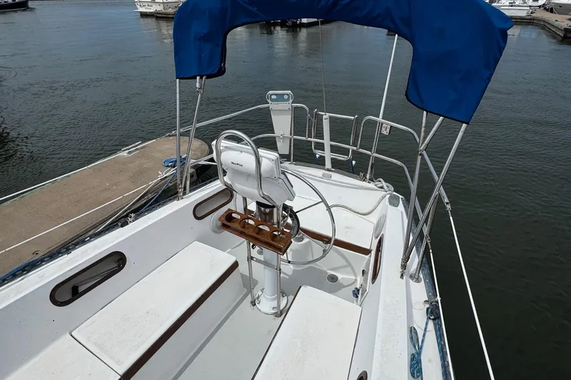 Slide: The Image of 1986 Catalina 38 sailboat cockpit with blue canopy, docked at marina. - 7