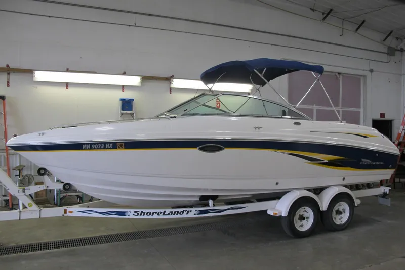 The Image of 2000 Chaparral 230 SSi boat on trailer in indoor storage facility. - 0